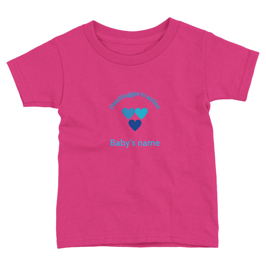 aa904889-d96f-4169-bf11-1cd51fa10e29 Toddler t-shirt with 'Hearthugger in Action' design, customizable with name on front, 'Loved by all' on the back." Sizing Chart: "Size chart for a toddler t-shirt with measurements in inches and centimeters."